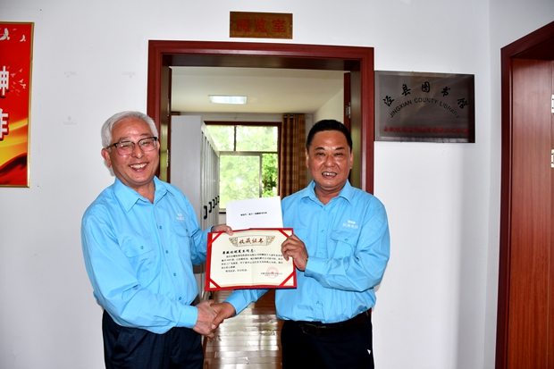 公司工會主席許鋒（右）向公司監(jiān)事會主席、捐書人胡夏生頒發(fā)《收藏證書》